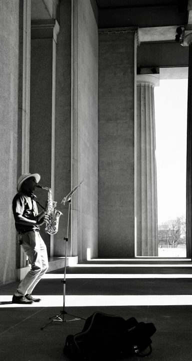 man in black and white jacket playing trumpet